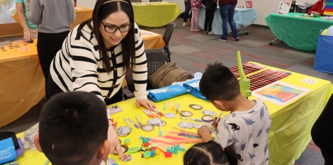 Maria teaching children how to make their own button